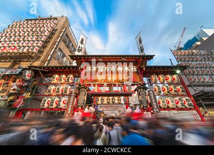 akihabara, japan - november 08 2019: Crowds agglutinated at the  gate of the Ootori shrine decorated with paper lanterns to buy auspicious bamboo rake Stock Photo