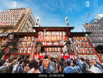 akihabara, japan - november 08 2019: Crowds agglutinated at the  gate of the Ootori shrine decorated with paper lanterns to buy auspicious bamboo rake Stock Photo