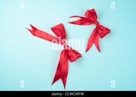 Two Red satin bows on a light blue background. Stock Photo