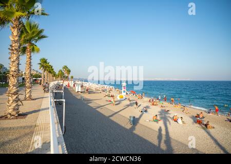 Antalya, Turkey - 2.09.2020: Konyaalti sand beach and Taurus mountains in sunset light, Antalya, Turkey