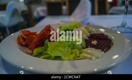 healthy salad mix on a white plate in a restaurant Stock Photo