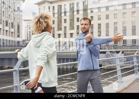 Young people standing on the street and warming up before sports training in the city Stock Photo