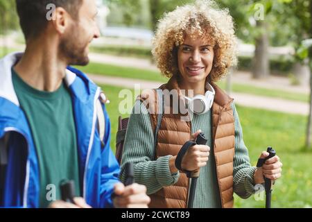 Young happy woman smiling and talking to young man during their sport walking in the park Stock Photo