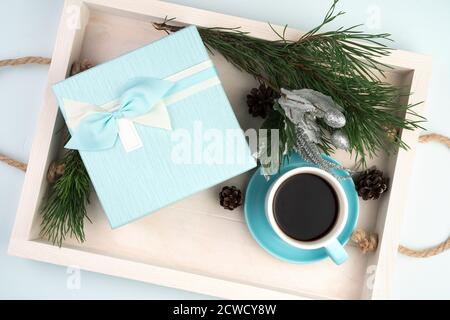 Gift box with a Cup of coffee Christmas balls and a spruce branch on a white tray. Stock Photo