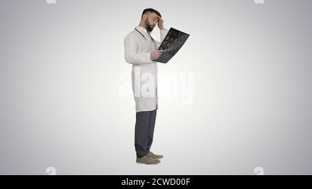 Physician reading and reviewing a MRI brain scan on gradient bac Stock Photo