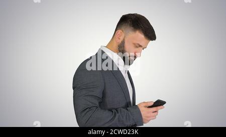 Turk businessman walking and using smartphone on gradient backgr Stock Photo