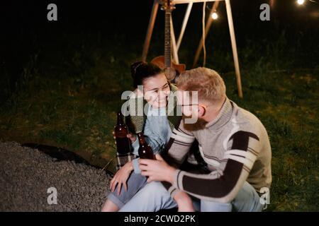 Couple have a good time together on night picnic drinking beverage from bottles Stock Photo