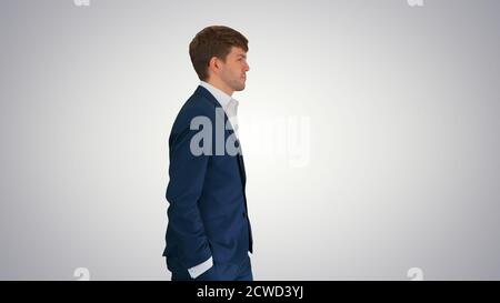 Young confident businessman walking with his hands in his pocket Stock Photo
