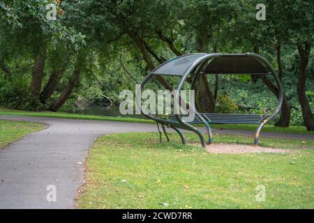 Boultham Park, park bench, picnic shelter, metal construction, oval shape, open spaces, Lincoln, trees, footpaths, outdoors, space-age, greenery. Stock Photo