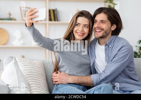 Portrait of young lovers taking selfie on smartphone Stock Photo