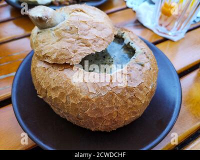 Soup in bread is a dish of the Czech Republic. Mushroom soup puree Stock Photo