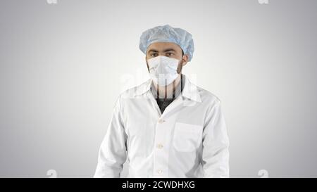 Mature surgery in a mask walking Front view on gradient backgrou Stock Photo