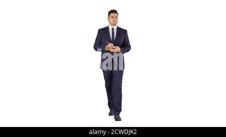Handsome experienced manager writing in notebook his ideas while walking on white background. Stock Photo