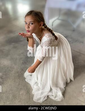 Portrait of a seven year old girl dressed up in a flower girl or communion dress Stock Photo