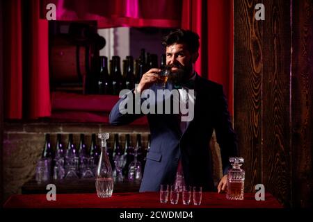 Bartender preparing cocktail. Macho drinking. Stylish rich man holding a glass of old whisky. Gentleman drink cognac or whiskey. Stock Photo