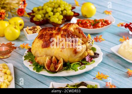 Thanksgiving dinner with turkey or chicken served with potato and apple on blue wooden table.. Stock Photo