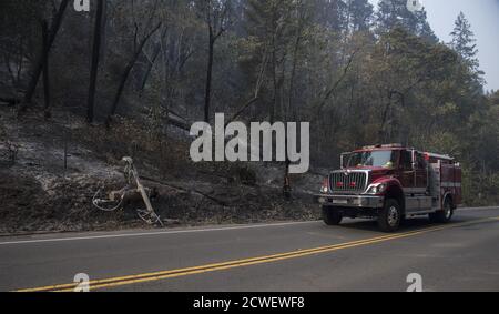 Angwin, United States. 29th Sep, 2020. A fire engine pases a burning high volltage power pole beside the road in Angwin, California on Tuesday, September 29, 2020. The Glass Fire has burned over 40,000 acres and is only 2% contained. Photo by Terry Schmitt/UPI Credit: UPI/Alamy Live News Stock Photo