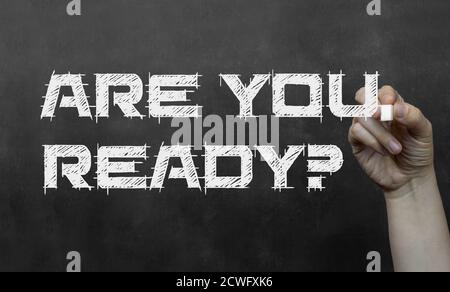 Are you ready phrase on a blackboard, written with chalk in a hand. Stock Photo