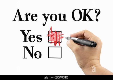 Are you OK? Stressed, depressed feeling. Phrase and checkbox on a whiteboard, written with black and red marker in a hand. Scribble sketch text on a b Stock Photo