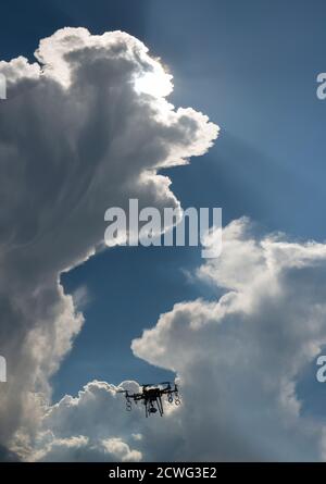 Dron flying in the sky. Blue sky and beautiful white clouds Stock Photo