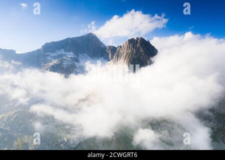 Aerial view of Furkahorn mountain peak emerging from clouds, Furka Pass, Canton Uri, Switzerland Stock Photo