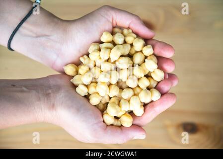 Raw chickpeas in woman's hands, top view Stock Photo
