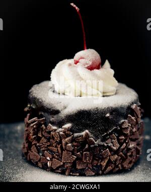 Delicious chocolate cake with cherry on the top icing Stock Photo