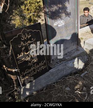 An epitaph (L) for Mohammad Afzal Guru is seen at the Mazar-e-Shohda (Martyr's graveyard) in Srinagar February 12, 2013. India hanged Mohammad Afzal Guru, a Kashmiri man, on Saturday for an attack on the country's parliament in 2001, sparking clashes in Kashmir between protesters and police. Security forces had imposed a curfew in parts of Kashmir and ordered people off the streets. The writing on the epitaph reads: 'Martyr of homeland Mohammad Afzal Guru, Martyrdom date February 9, 2013, whose mortal remains are lying with the government of India and the nations is waiting for its return'. RE