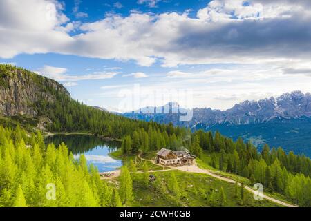 Green woods surrounding Rifugio Croda da Lago hut and Lake Federa in summer, Ampezzo Dolomites, Belluno province, Veneto, Italy Stock Photo