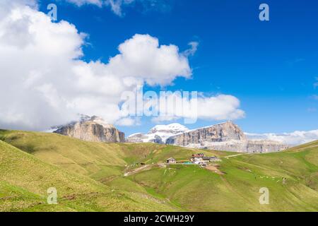 Rifugio Friedrich August surrounded by green meadows in summer, Passo Sella, Dolomites, Val di Fassa, Trentino, Italy Stock Photo