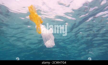 Plastic bag in blue ocean water. Plastic pollution in ocean environmental problem. Ecological problem, Environmental Pollution. Stock Photo