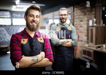 Portrait of young male barbers and hairdressers in barber shop Stock Photo