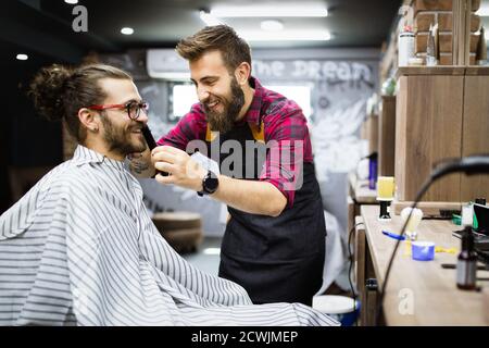 Client during beard shaving in barber shop Stock Photo