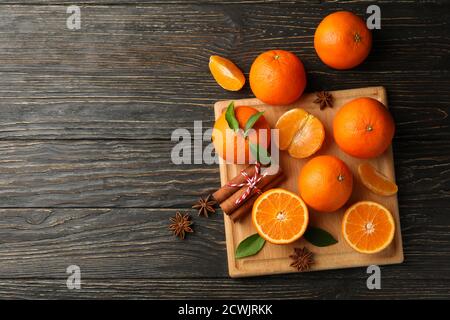 Board with mandarins and cinnamon on wooden background Stock Photo
