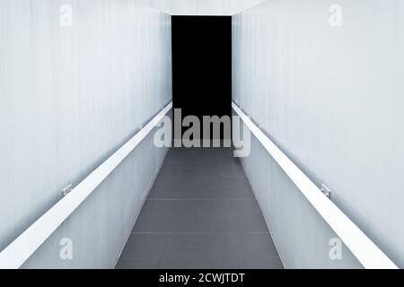 Concrete corridor with white wall and granite tile to black door Stock Photo