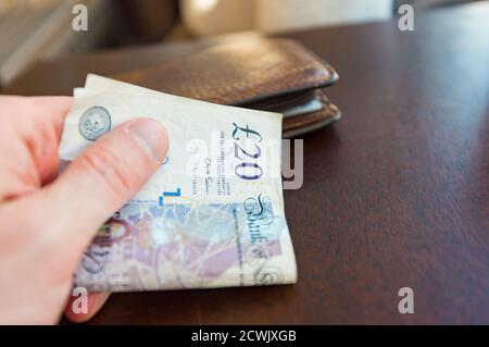 Man paying by 20 pound notes at cafe or shop in London Stock Photo