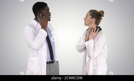 Female and male doctor using mobile phones making calls telling Stock Photo