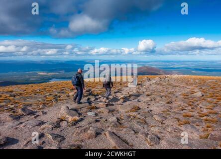 Walkers decend on the path from the summit of the mountain of Cairn Gorm, a munro near the Cairngorm Ski Centre at Aviemore, Scotland, UK Stock Photo