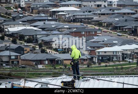 Melbourne residential construction scene; A builder working on a roof of a building in a Melbourne suburb . Stock Photo