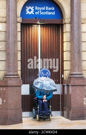 Disabled city centre shoppers sheltering from the rain in the north west.  Central Lancashire is the epi-centre of Covid 19 resurgence with a high transmission rate of the virus, and severe restrictions are in force limiting traffic and access in the Central Business District. Stock Photo