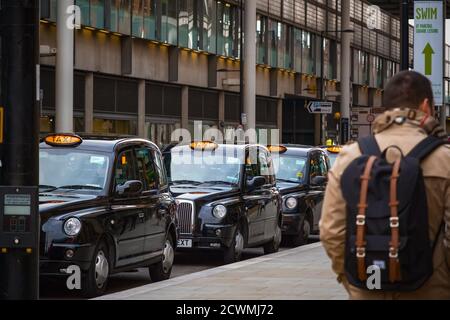 London, UK - February 2, 2020 - London black cabs queuing at cab stand for customers outside Kings Cross station Stock Photo