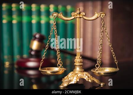 golden scale in front of judge's gavel and law books, justice concept Stock Photo