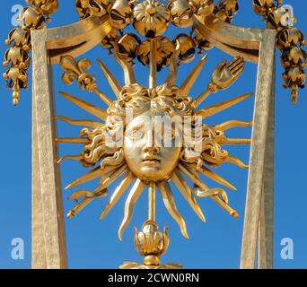 Symbol of Louis XIV the Sun King on the golden gate of Versailles Castle Stock Photo