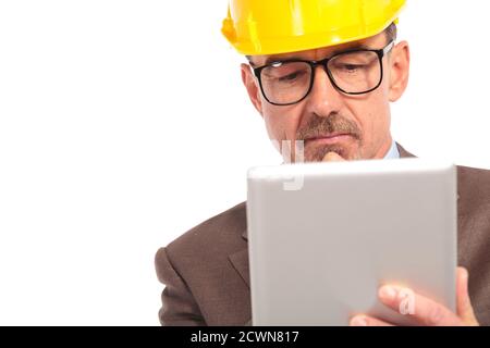 concerned senior construction engineer reading on his tablet computer on white background Stock Photo