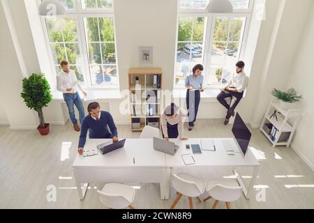 Serious young company employees preparing for corporate meeting in spacious office room Stock Photo