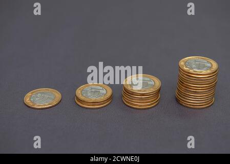 Stacks of golden and silver coins (1 Real) as in a growing graph, representing rise or fall on black bacground. Economy concept. Copy space. Selective Stock Photo