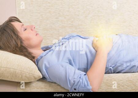 Woman practicing self Reiki transfering energy through palms, a kind of energy medicine. Stock Photo