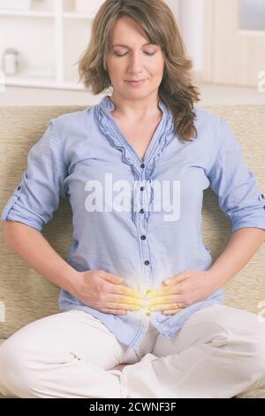 Woman practicing self Reiki transfering energy through palms, a kind of energy medicine. Stock Photo