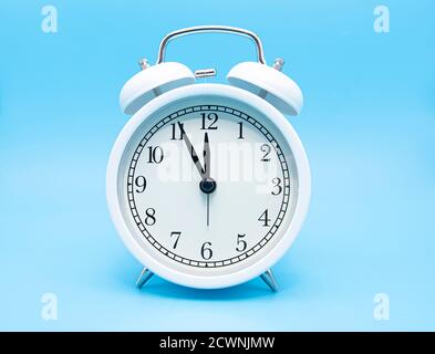 White classic alarm clock on blue background, concept picture Stock Photo