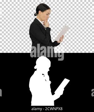 Businesswoman using a tablet pad while walking, Alpha Channel wi Stock Photo